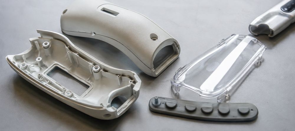 Injection moulded ABS enclosure halves, a polycarbonate lens cover and a rubber button strip for a handheld device
